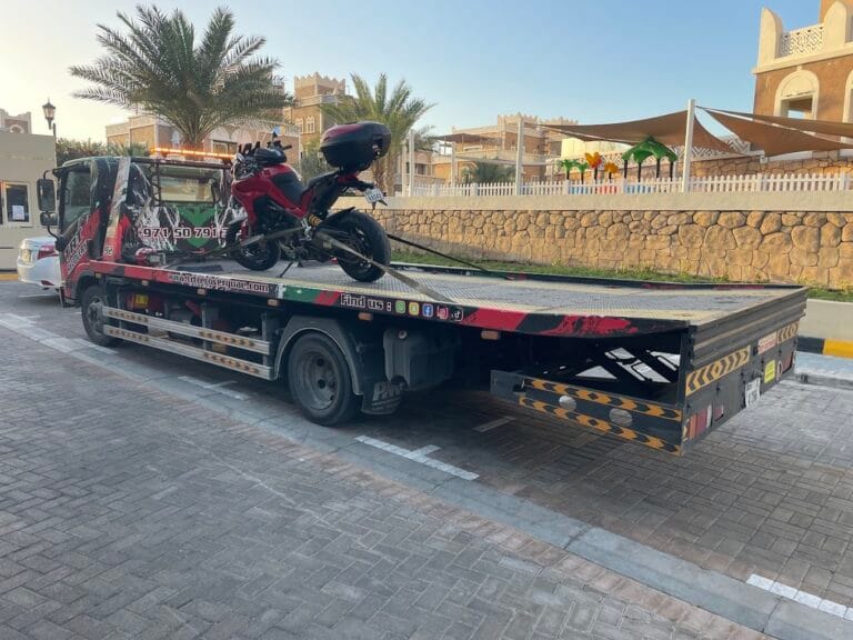 Professional motorcycle towing Dubai, secure tie-down straps on a roadster during transport