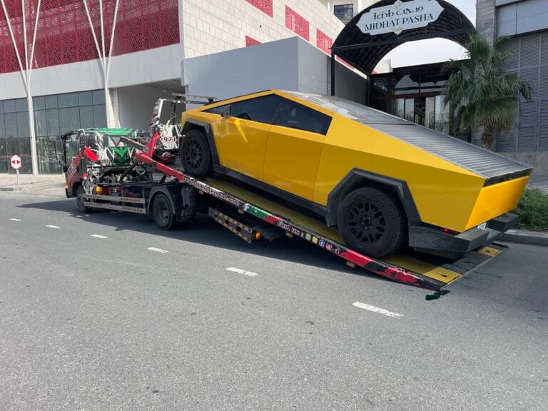 Professional car towing Dubai service, flatbed recovery truck loading a car safely